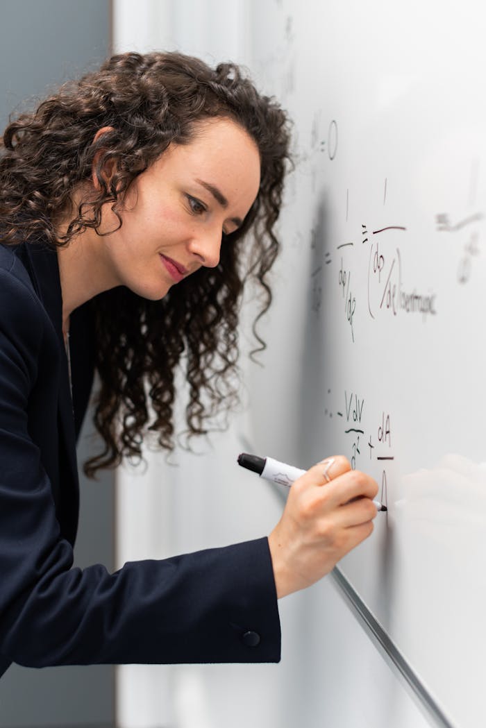 why-choose-us Female engineer solving equations on whiteboard with focus and precision.